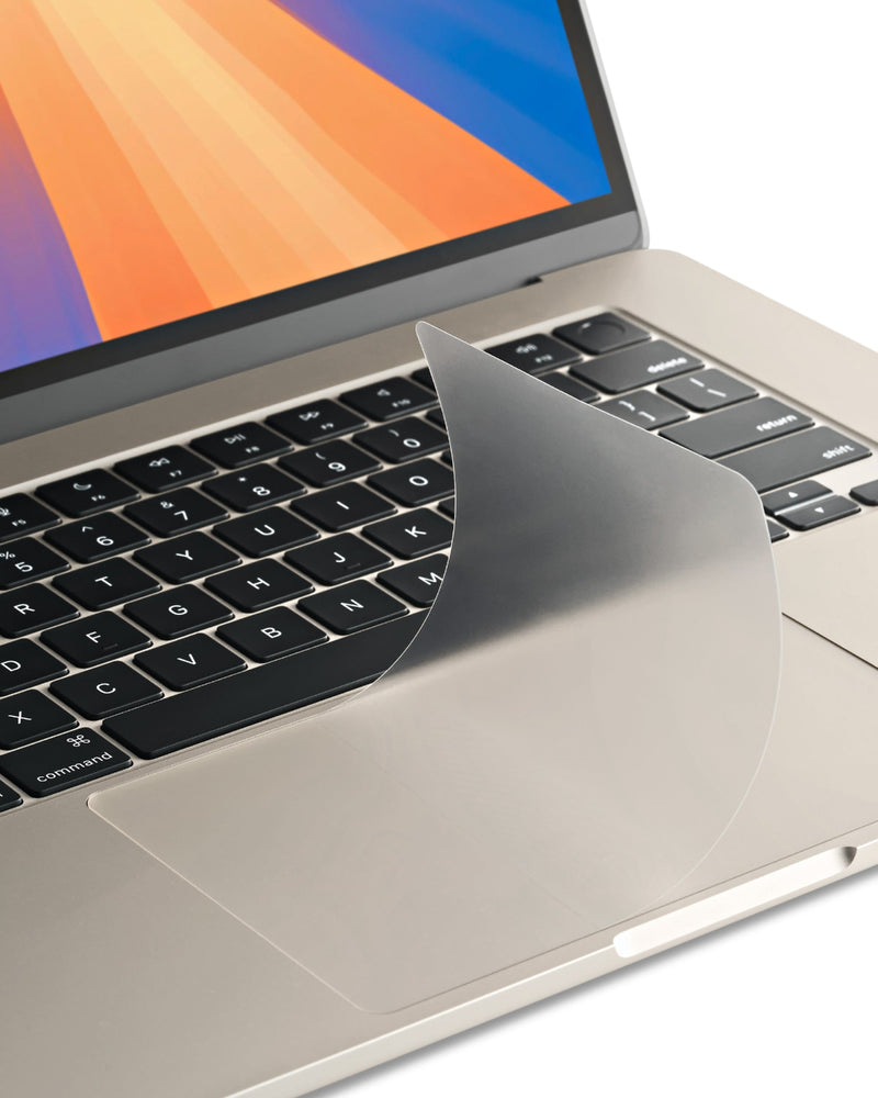 Close-up of a GhostCover Touch trackpad protector being smoothed onto a MacBook trackpad