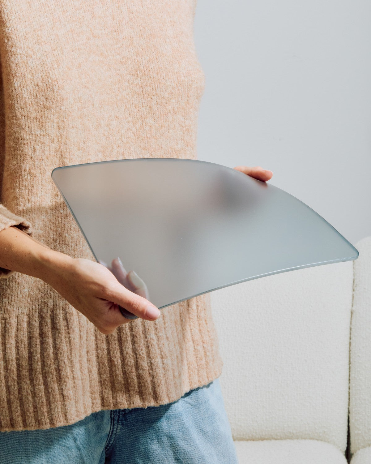 Hands slightly bending a translucent GhostShell case shell showing its lightweight and flexibility