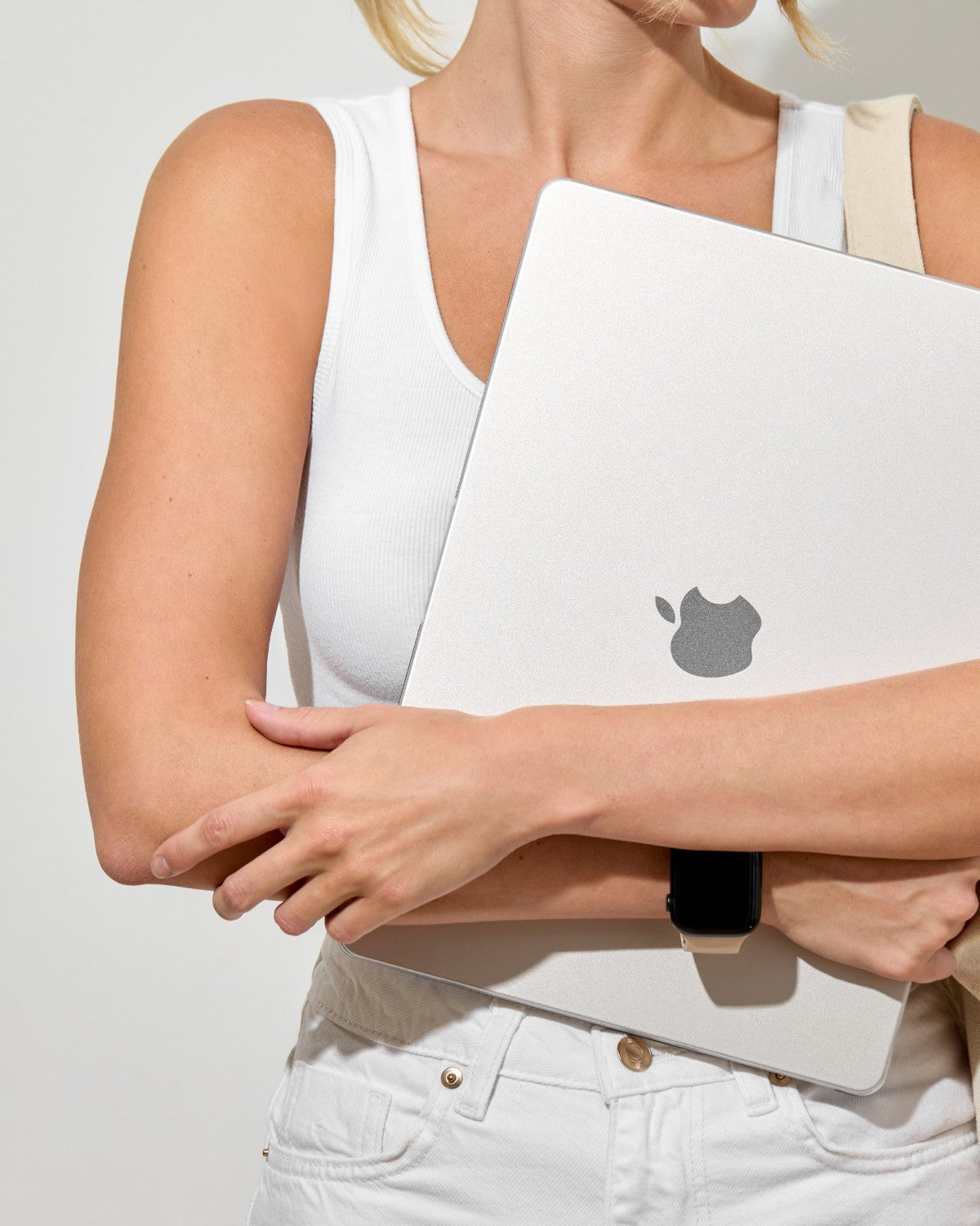 Person carrying a MacBook Pro in a clear GhostShell Frost case against their chest