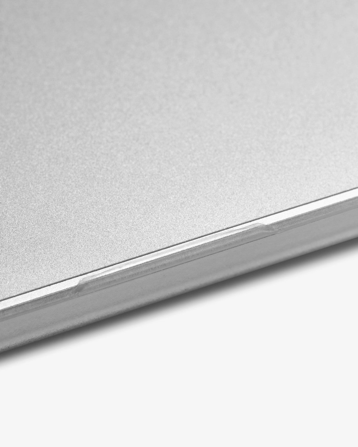 Edge of a Silver MacBook Air with GhostShield palm rest protector and GhostShell case fitted together