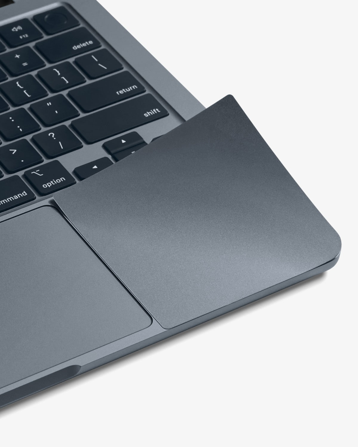 Close-up of a color-matched GhostShield palm rest protector on a Midnight MacBook Air.