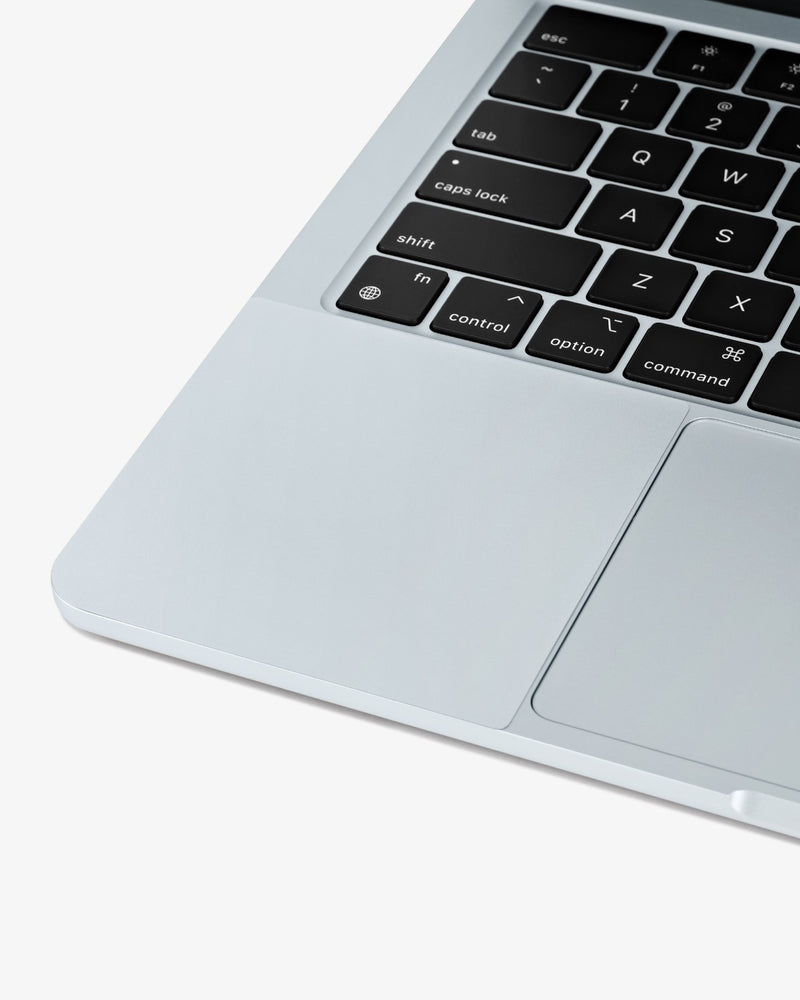 Close-up of a color-matched GhostShield palm rest protector installed on a Sky Blue MacBook Air.