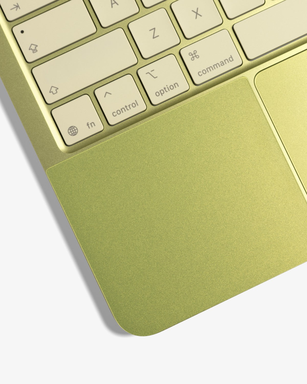 Close-up of a color-matched GhostShield palm rest protector installed on a citrus MacBook Neo.