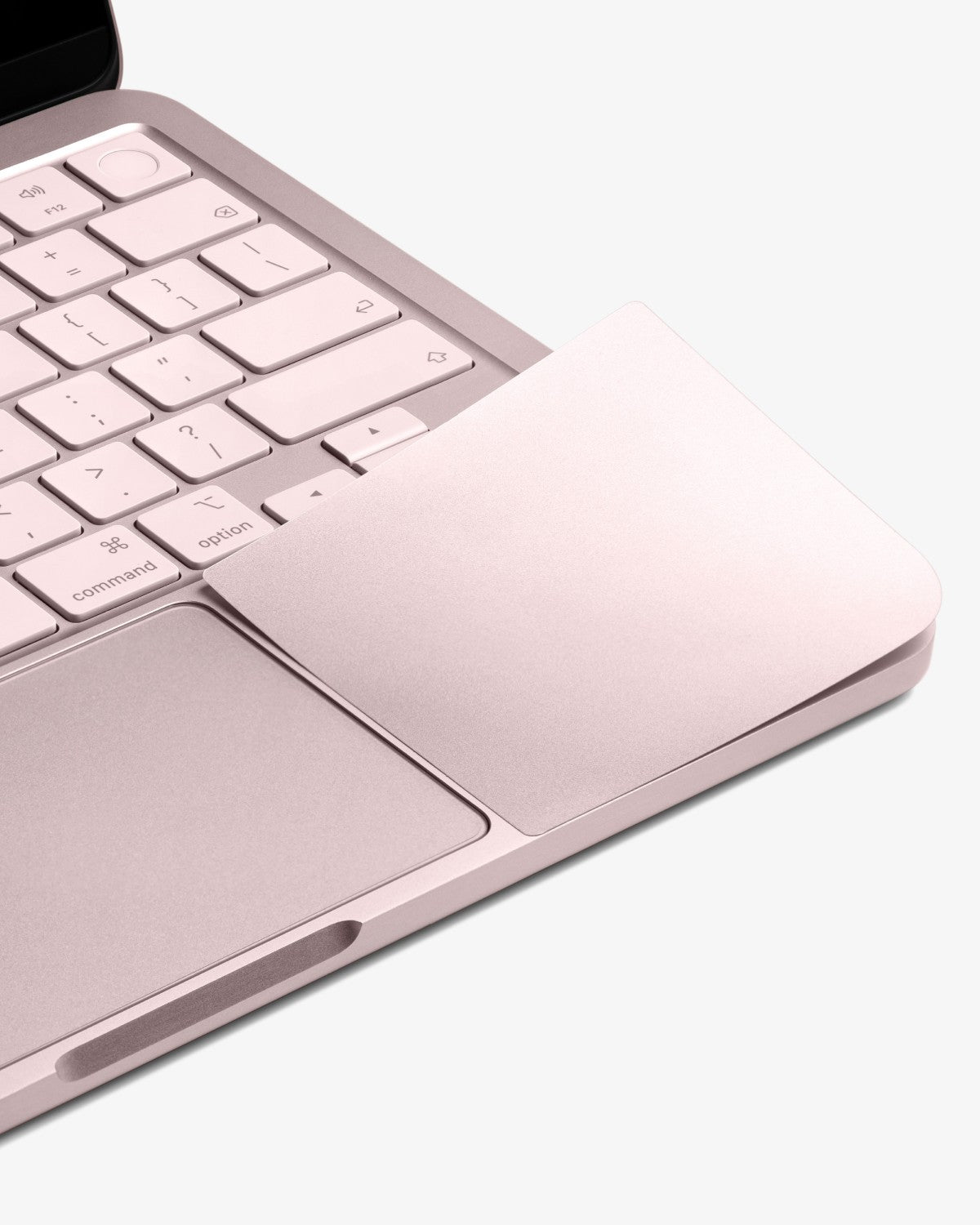 Close-up of GhostShield palm rest protector on a Blush MacBook Neo, blended into the keyboard deck