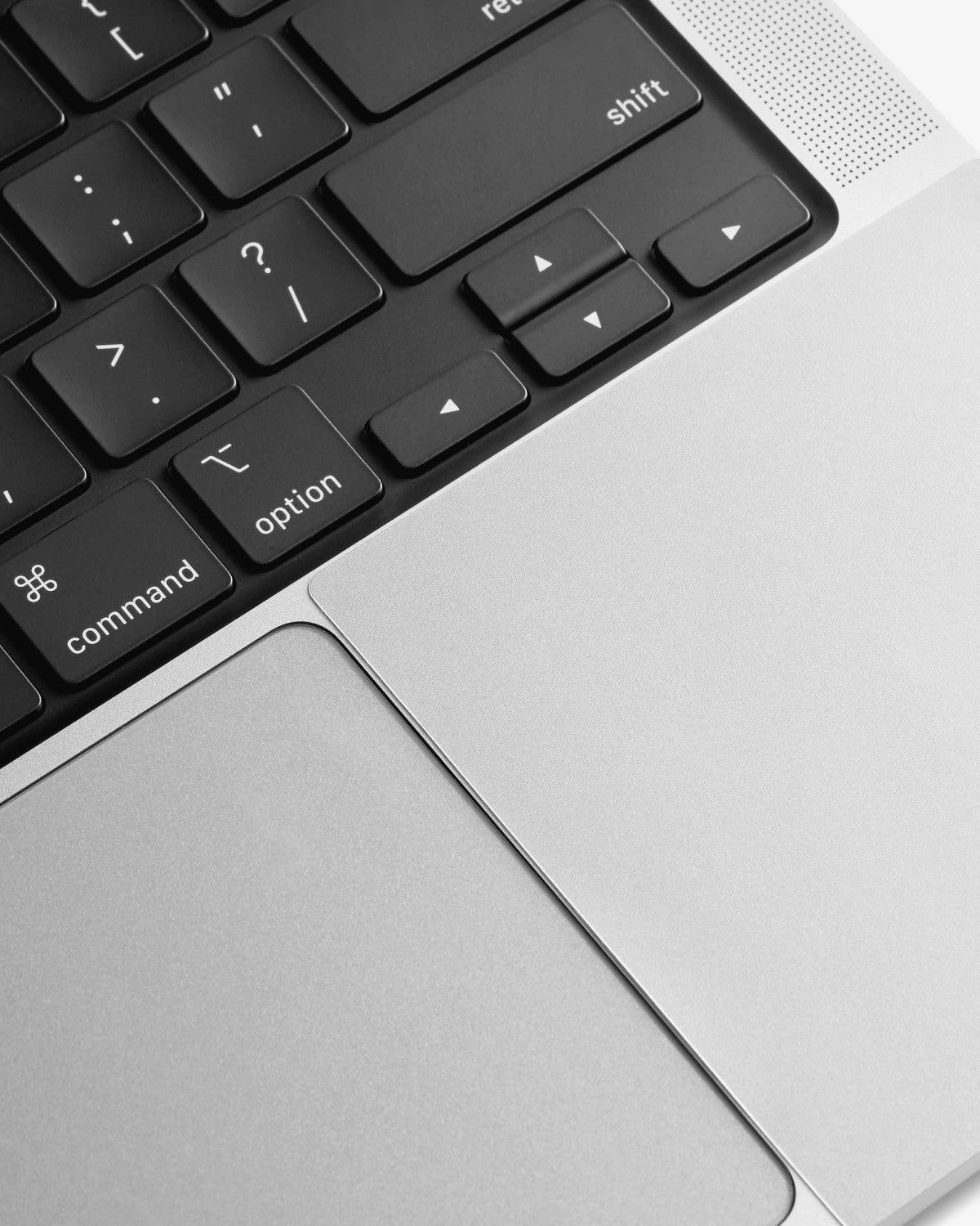 Close-up of a color-matched GhostShield palm rest protector installed on a Silver MacBook Pro.